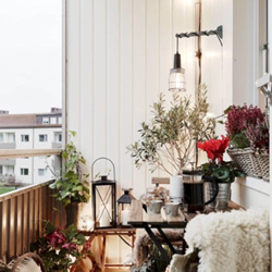 A balcony with plants and a table with plants and lights