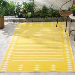 A yellow rug with white arrows on it