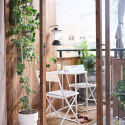 A glass door with a table and chairs and a plant