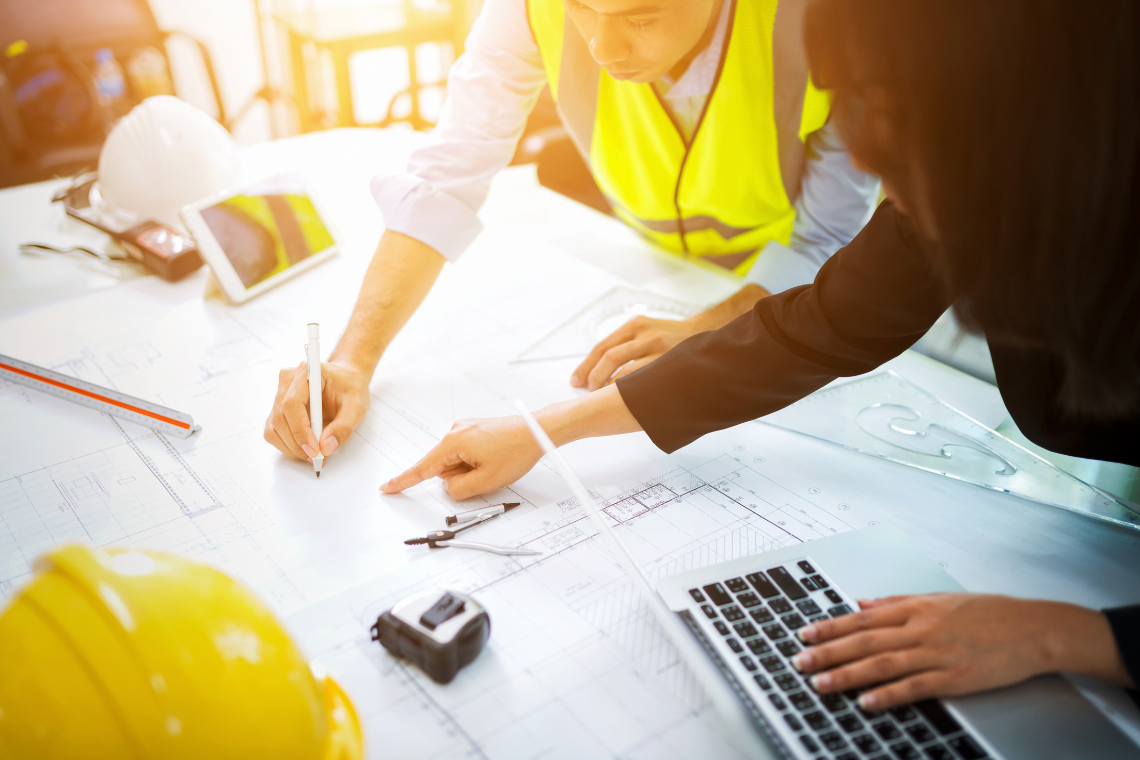 Two people drawing in an architectural plan