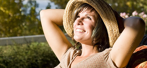 Woman sitting on a patio chair relaxing at home by the lake