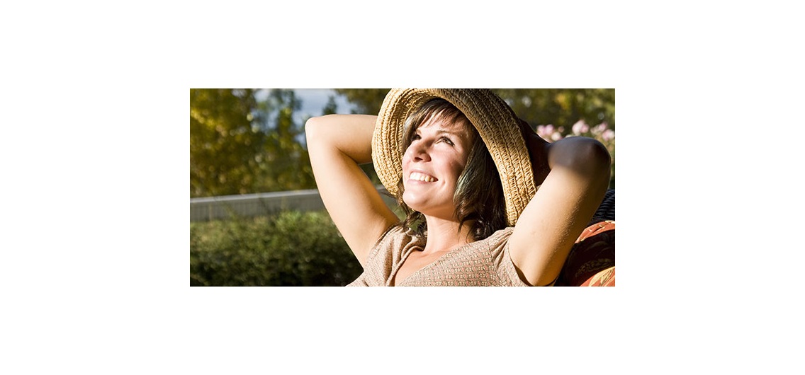 Woman sitting on a patio chair relaxing at home by the lake