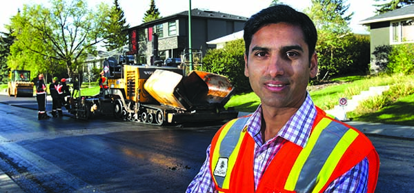 Venkat Lakkavalli, pavement engineer with the City of Calgary, beside a paving crew in the southwest community of Killarney. Photo by Wil Andruschak/for CREB®Now
