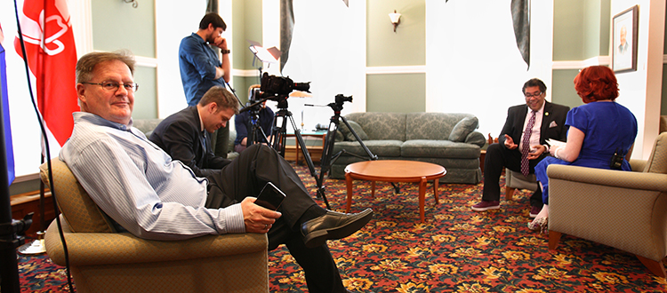 In-Houze Productions co-founder Doug Hayden sits in the foreground while his team interviews Calgary Mayor Naheed Nenshi for an upcoming Shaw TV series titled Calgary Homes & Lifestyles.