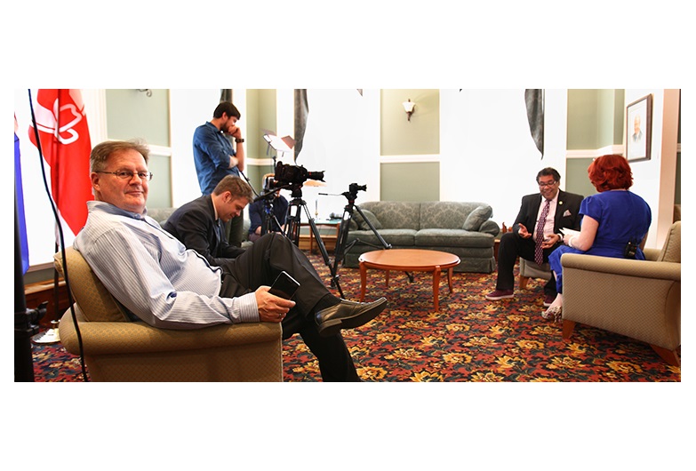 In-Houze Productions co-founder Doug Hayden sits in the foreground while his team interviews Calgary Mayor Naheed Nenshi for an upcoming Shaw TV series titled Calgary Homes & Lifestyles.