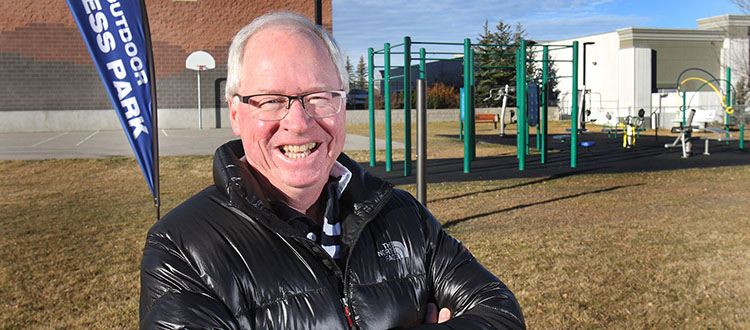 Dave McCarrel stands next to a new outdoor fitness park in Valley Ridge that opened earlier this fall. McCarrle has kept active within the local community association over the past 20 years because he feels it has helped make Valley Ridge a better place to live. Photo by Wil Andruschak/For CREB®Now