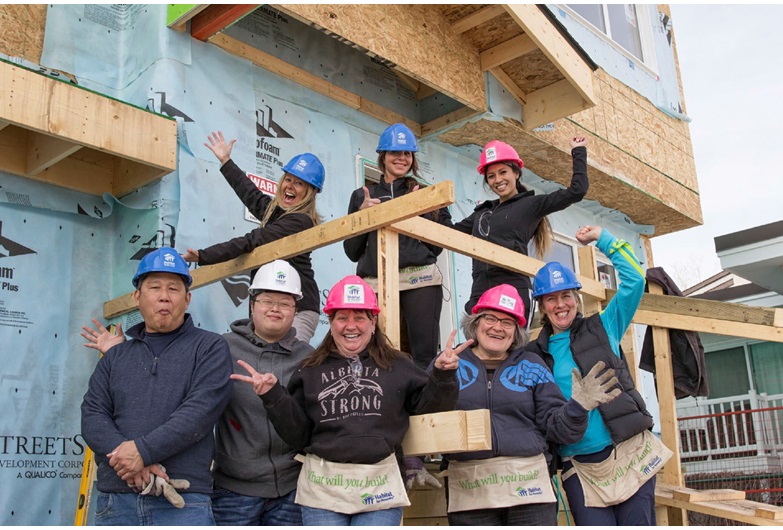 A group of Calgary and area REALTORS® celebrate a habitat for Humanity build in the community of Pineridge. 